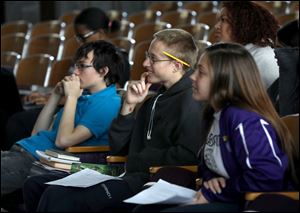 Waite High School senior Kyle VanDyne, center, smiles as he listens to his fellow social studies students practice reading their scripts for the Fallen Heroes Memorial Program at Waite High School in Toledo.