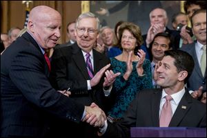 Speaker of the House Paul Ryan, R-Wis., right, shakes hands after presenting a pen to House Ways and Means Committee Chairman Kevin Brady, R-Texas, left, as Senate Majority Leader Mitch McConnell, R-Ky., second from left, watches after signing the final version of the GOP tax bill during an enrollment ceremony at the Capitol in Washington, Thursday, Dec. 21, 2017.