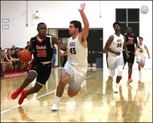 Joey Holifield of Cardinal Stritch drives to the basket against Notre Dame-Cathedral Latin's Brian Carney.