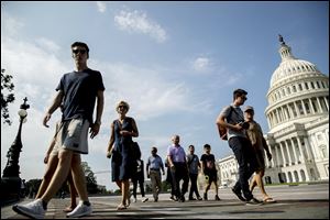 Tourists walks past the Capitol Building in Washington.