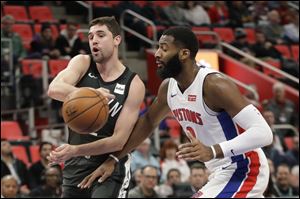 Brooklyn Nets guard Joe Harris passes the ball as Detroit Pistons center Andre Drummond closes in.