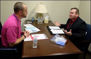 Owens Corning's Justin Powell, left, role plays as a buyer with University of Toledo's Mason Cordes during the University of Toledo's Invitational Sales Competition.