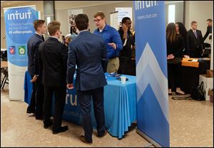 Intuit's Eric Pfeiffer talks with college students during a job fair, which is part of the University of Toledo's Invitational Sales Competition at UT's Savage and Associates Business Complex in Toledo.