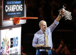 Michigan head coach John Beilein holds up the net after Michigan beat Purdue 75-66 to win the Big Ten Tournament.