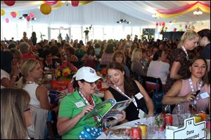 Crystal Jordan, center left, and Alison Carter, center right, consult their program booklet together during the Marathon Classic Women's Summit.