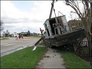 Women walk past a beached vessel on East Front Street in New Bern, N.C., on Thursday, Sept. 20, 2018. 