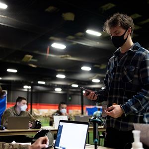 Devon Homier, 18, of Monclova, a full time student at Miami University, checks in with Corporal Baumer, 22, of Vickery, Ohio, so Homier can get a Coronavirus test at the Lucas County Recreation Center in Maumee. (THE BLADE/STEPHEN ZENNER)