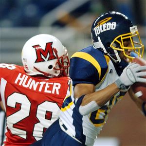 Toledo's Steve Odom (80) pulls in a touchdown pass while defended by Miami's Darrell Hunter (28) during the first quarter in the MAC Championship game at Ford Field in Detroit on Dec. 2, 2004.