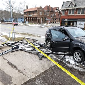 A Mercedes-Benz SUV rests on a snowbank after flattening a bus shelter near the intersection of Collingwood Boulevard and Delaware Avenue in Toledo.