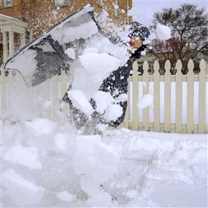 Grant Prater, 10, clears snow off the sidewalk on North Superior Street, Feb. 18,  in Toledo. 