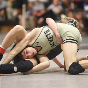 Perryburgu2019s Cole Evans, front, and St. Edwardu2019s Adam Butler wrestle at 106 pounds during the OHSAA Division I district wrestling tournament at Perrysburg High School in Perrysburg on Saturday. (THE BLADE/KURT STEISS)