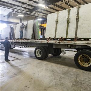 Workers unload slabs of countertops at Cutting Edge Countertops in Perrysburg.