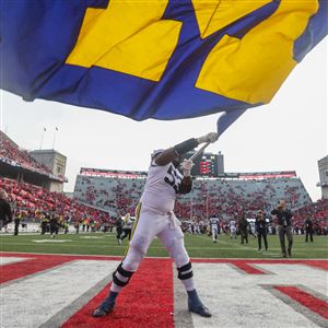 Michiganu2019s Trente Jones waves the Michigan flag after defeating Ohio State, 45-23 in a Big Ten football game at Ohio Stadium in Columbus, Nov. 26.