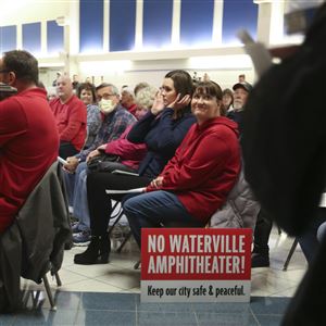 Waterville resident Shannon Bostelman brings her own sign to the final council meeting for the Waterville Landing Entertainment District amphitheater project.