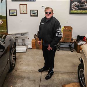 Perrysburg native Jerry Glanville stands surrounded by cars, art and memorabilia from his time as a Perrysburg High School football player and NFL coach on Dec. 14 at his home in Perrysburg. 