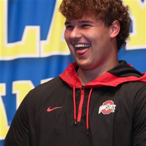 Findlay High School football player Luke Montgomery beams after affirming his commitment to play football at Ohio State during a ceremony Dec. 21 in Findlay.  