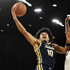 Toledo guard Ray J Dennis, left, drives to the basket against Miami's Morgan Safford in the Rockets' 81-78 win over the RedHawks on Tuesday night at Oxford, Ohio.