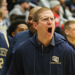 St. Johnu2019s coach Mike Schoen celebrates near the end of the game during an OHSAA Division I boys high school basketball regional final between St. Johnu2019s Jesuit and Garfield Heights at Kent State Universityu2019s Memorial Athletic and Convocation Center in Kent on March 11.